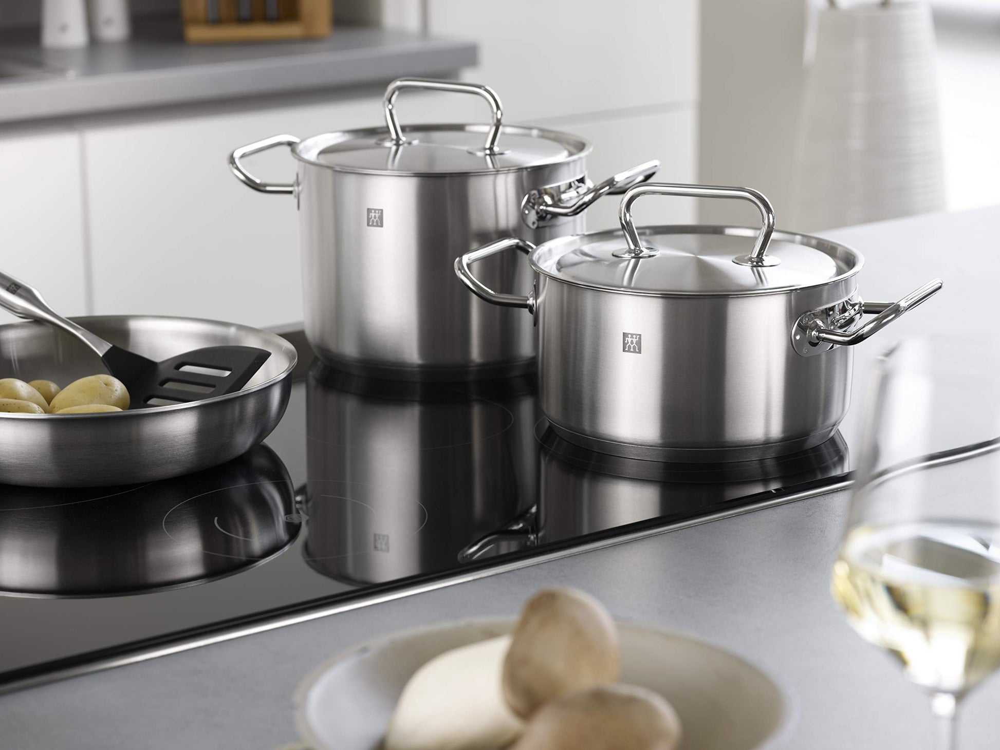 ZWILLING Twin Classic 12-Piece Stainless Steel Cookware Set – All Cooktops – Dripless Rims + Integrated Measuring Scale on a stovetop